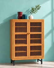 Wooden storage cabinet with slatted doors and decorative vases
