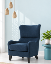 Blue upholstered armchair in a bright reading corner